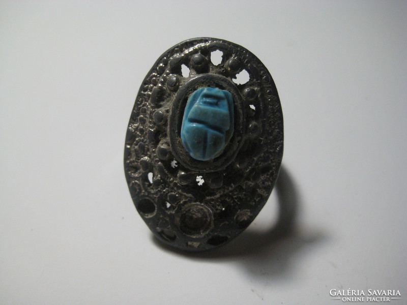 In the middle of an antique ring is a scarabeus beetle carved from a mineral