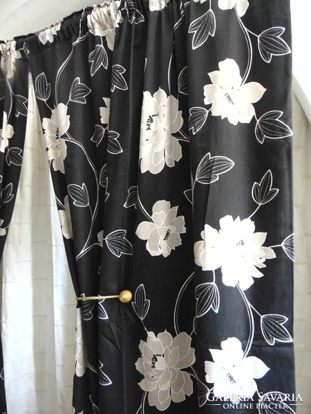 Beige flower patterned curtains on a black background