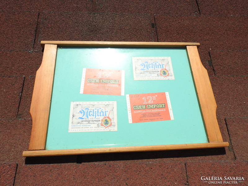Very retro pine wood tray decorated with beer labels behind glass
