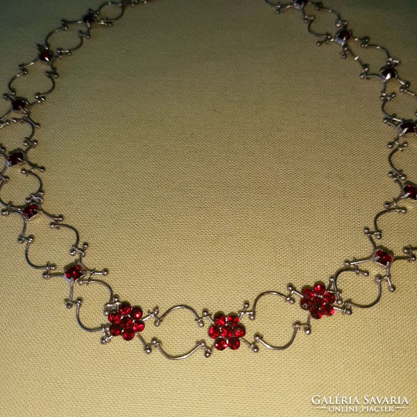 On a silver background, ruby red stone necklace, neck strap