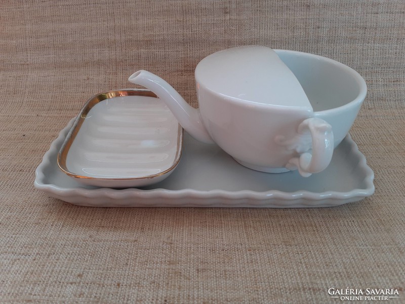 Old white porcelain drinking cup with gilded edge soap dish on porcelain tray in one