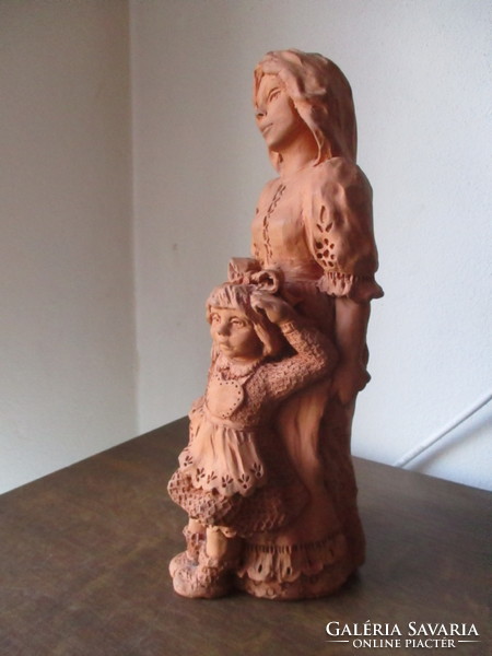 Very beautiful ceramic figurine of mother with her child with a copper sign