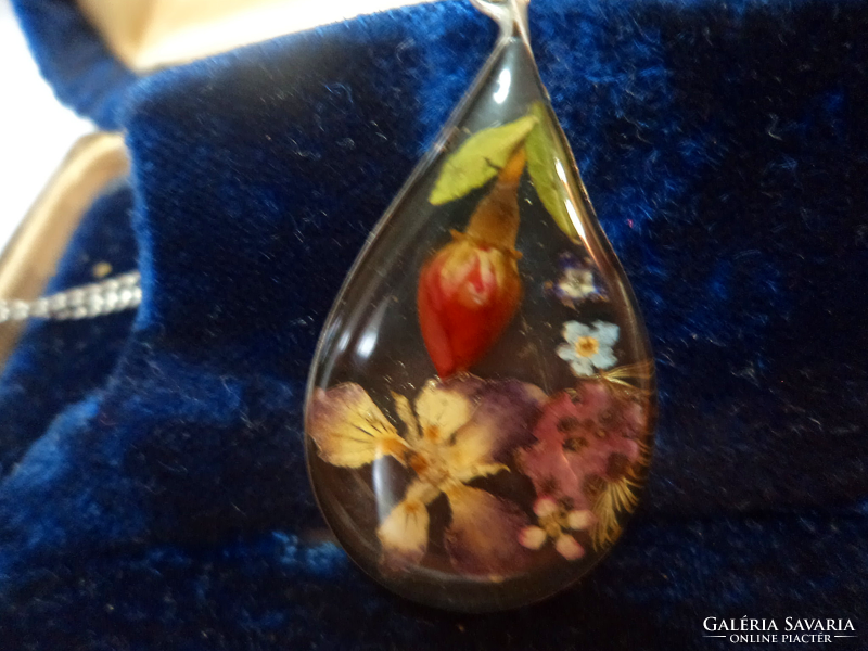 In a silver frame, silver chain-dried flowers cast in a pendant