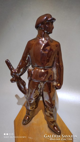 Vintage retro eosin glazed metal laborer statue on wooden sole