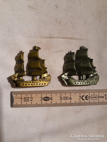 2 small metal sailing ships