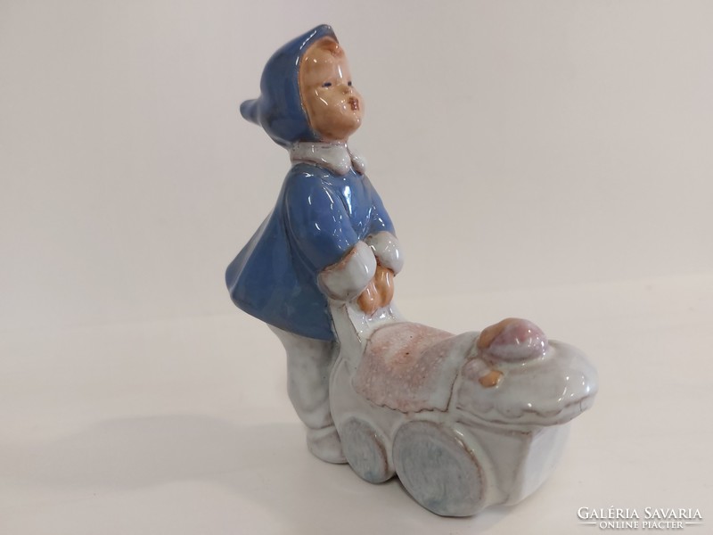 Little girl pushing baby car with pottery.