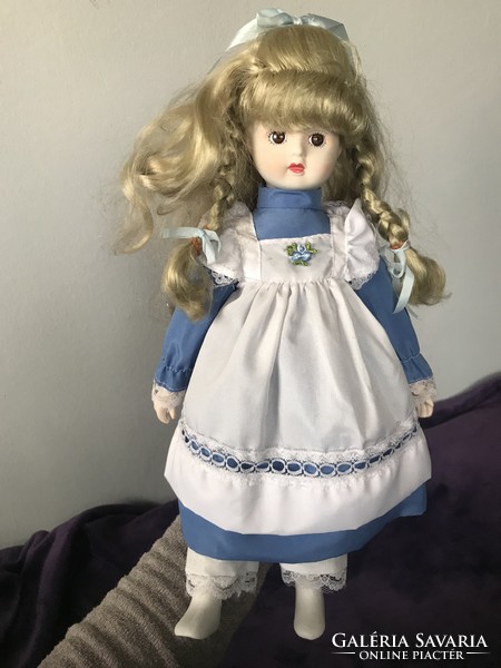 Beautiful blond porcelain doll with old blond hair in blue dress