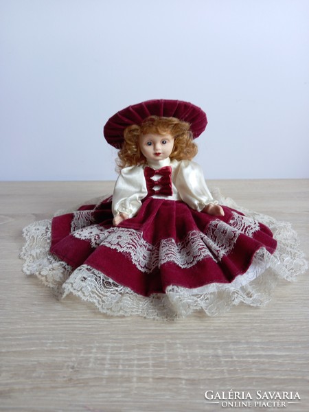 Porcelain doll in burgundy velvet dress