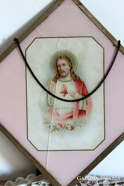 Antique holy image, hanging on the wall, in a metal frame, under a glass plate