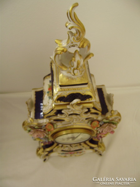Neo-baroque porcelain clock from the 1950s-60s is stored in a new condition in a display case for sale