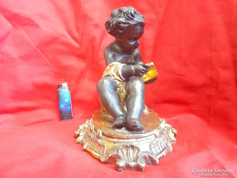 Baroque putto, figural statue of a book support reading an angel book.