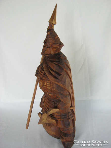 Wooden statue of a Viking warrior carved with a spear and an ax