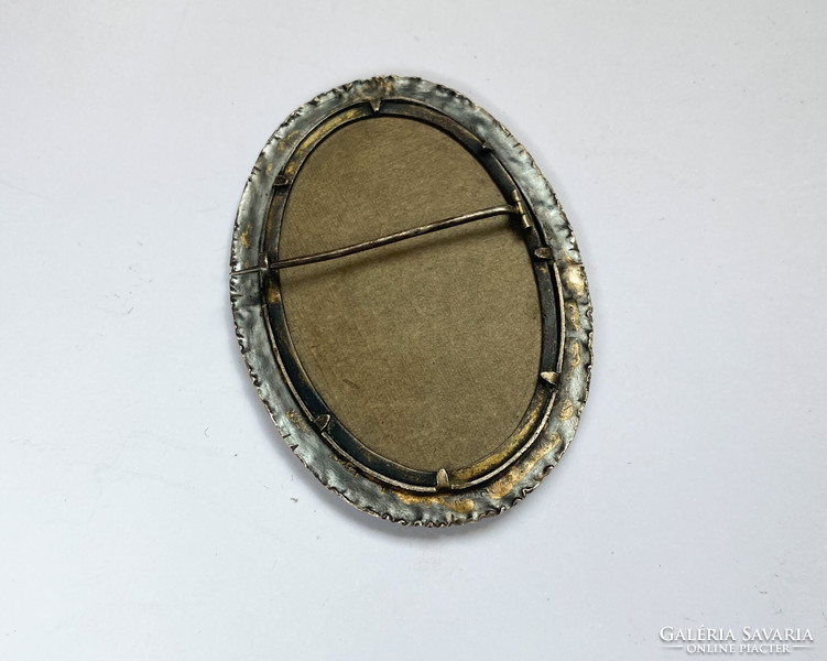 Old ornate silver brooch with tapestry image