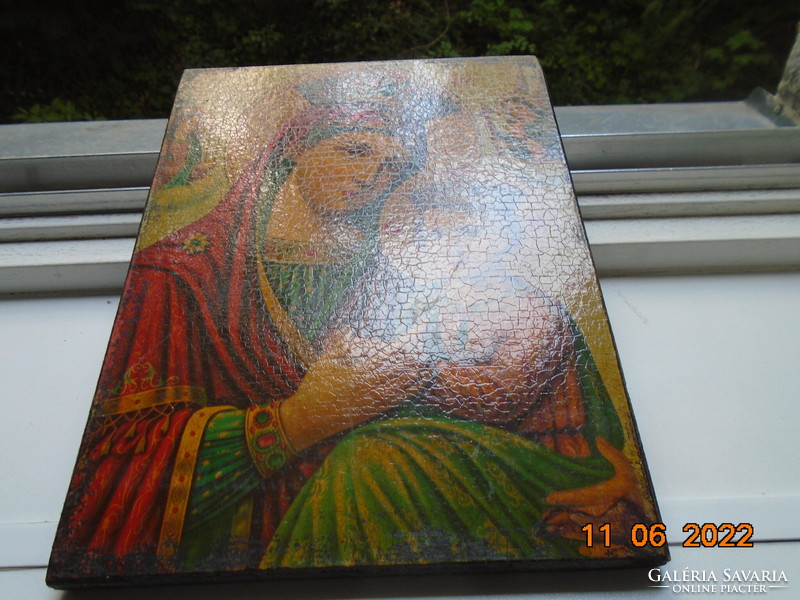 Print of an old painting of the crowned Mary with her little one on a wooden sheet expressing its shape and color scheme