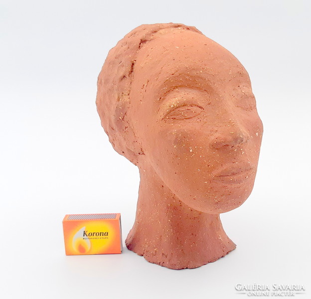 K. J. A terracotta Negro female bust with a sign