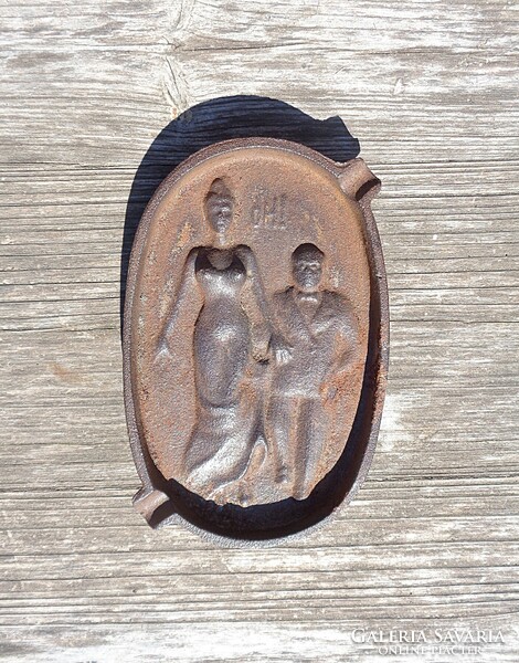 Old cast iron ashtray with front and back scenes