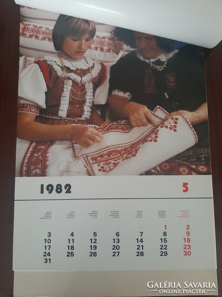 Wall calendar from 1982 showing Hungarian folk costumes by landscape