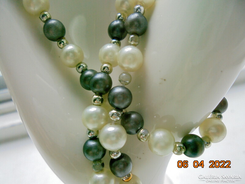 Necklaces made of shiny grayish black mineral, saltwater pearls and gold-colored intermediate pearls