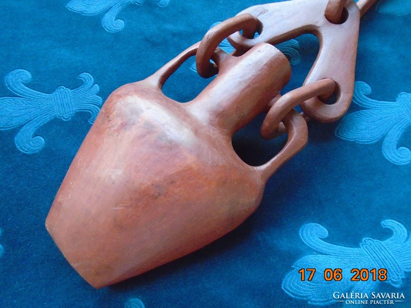 An ornamental water bottle carved from exotic wood with a chain
