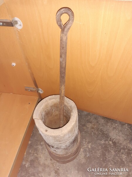 Old wooden mortar with tires, with an iron pestle