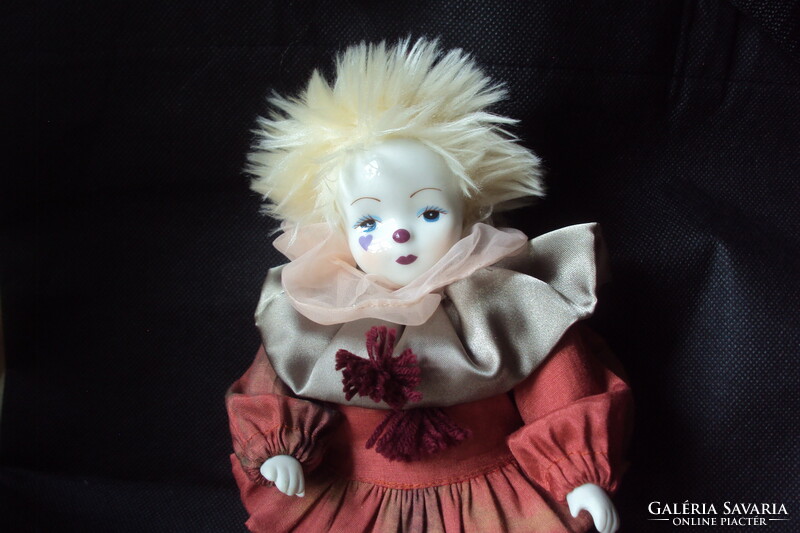 A cute little chubby clown with a porcelain head and limbs, a tufted hat, and a beautiful silk dress.
