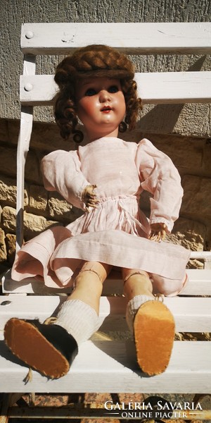 A doll with an antique porcelain head, a wooden body and a beautiful original piece marked with Buskvit