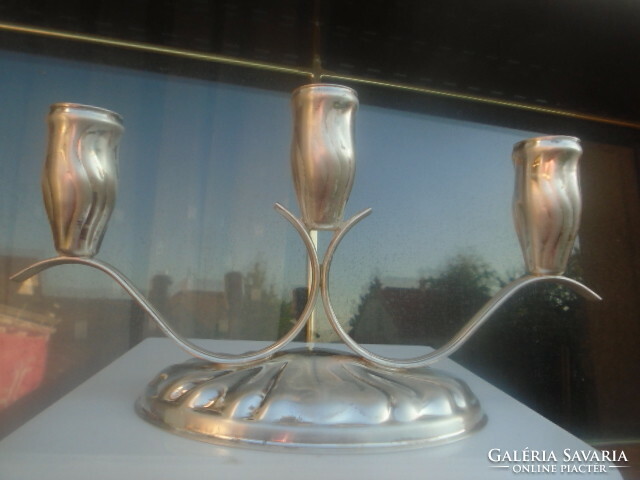A very finely crafted 3-pronged candle holder with a silver effect