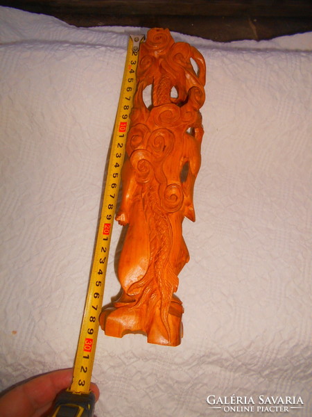 A meticulously crafted carved sandalwood laughing goofy figure with a dragon snake