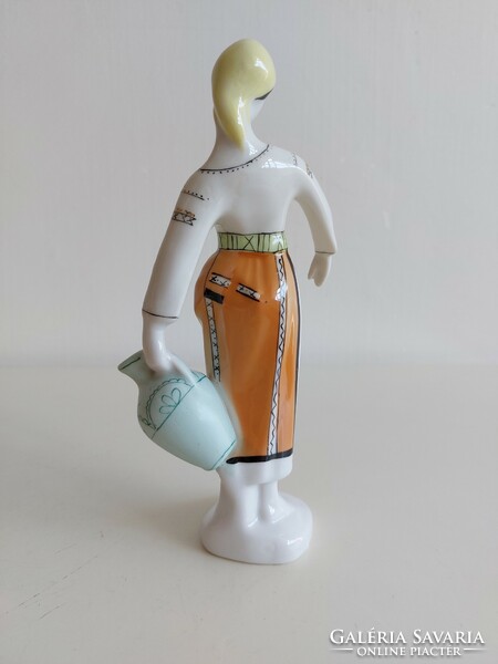 Old porcelain figurine of a lady in a shawl with a jug
