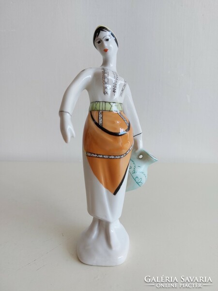 Old porcelain figurine of a lady in a shawl with a jug
