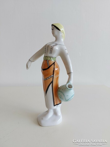 Old porcelain figurine of a lady in a shawl with a jug