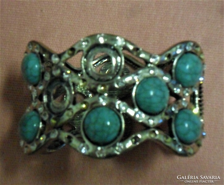 Silver metal bracelet with turquoise stones and rhinestones.