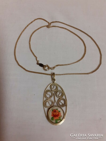 A filigree pendant on a chain adorned with tapestry in a beautiful retro condition
