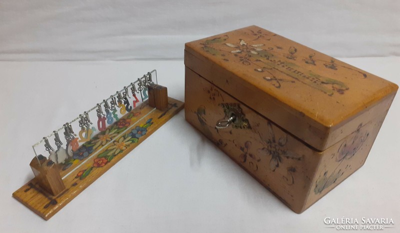 An old hand-painted small box of old mountain hay with a matching powder indicator holder with hook numbers