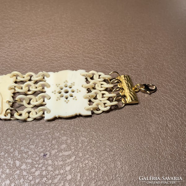 Old elephant patterned bone bracelet elaborately restored with gilded eyes, elephant bangle