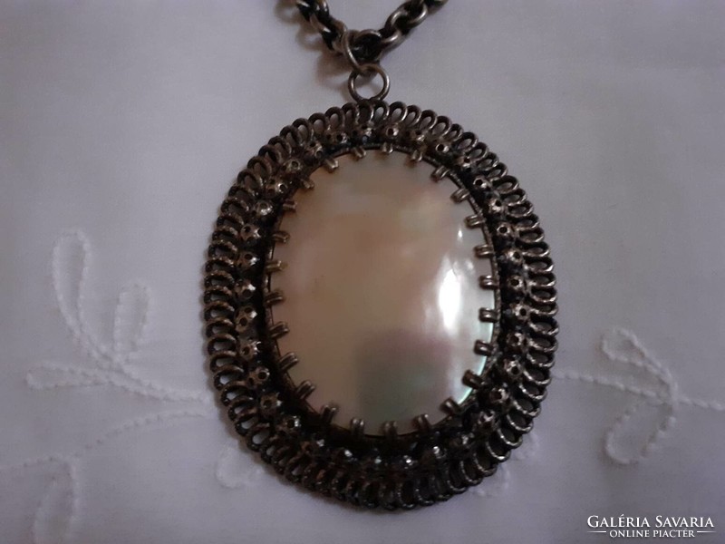 A beautiful silver-plated necklace with a large mother-of-pearl pendant
