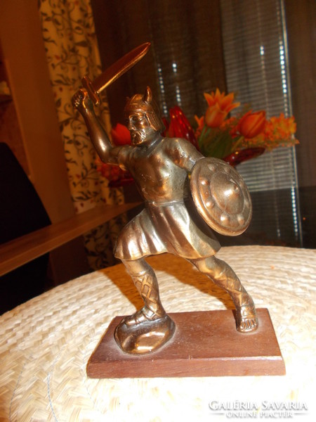 Old solid bronzed copper statue on a pedestal with a battle scene