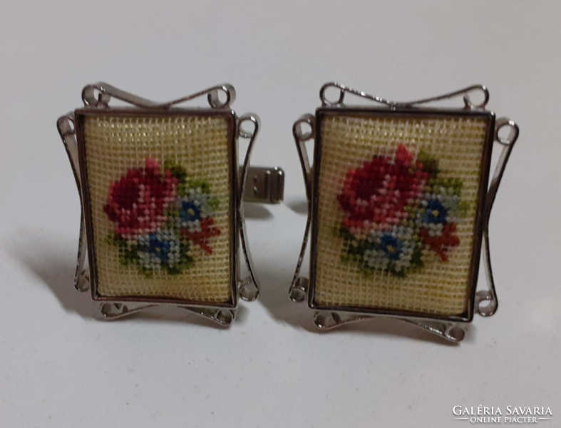 A cufflink in a filigree frame decorated with tapestry in an old, beautiful condition