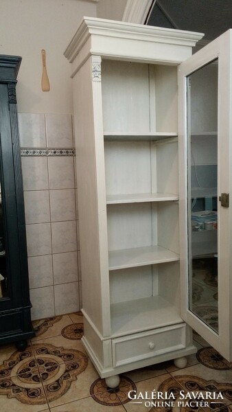 A narrow storage cabinet with bookshelves in German pewter