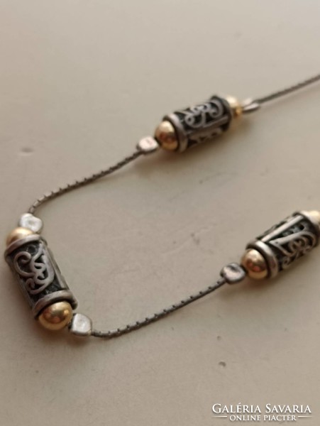 Silver necklace with openwork cylindrical decorations with gold-plated ends