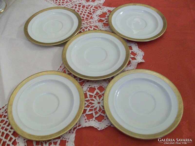 Porcelain tea cup coasters with a beautiful golden border on a snow-white background
