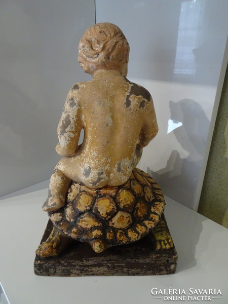 Antique marked ceramic turtle with putto traveling on its back.