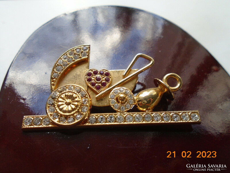 Gold-plated pram brooch with many red and clear cut stones
