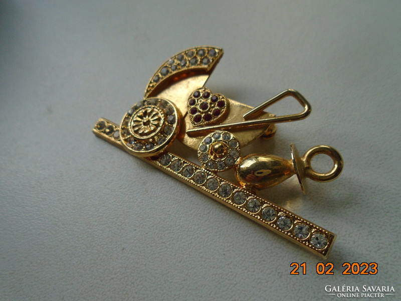 Gold-plated pram brooch with many red and clear cut stones