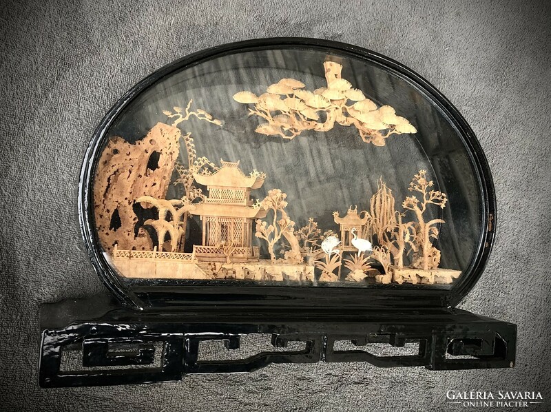 Old oriental carving in a wooden-glass display case.