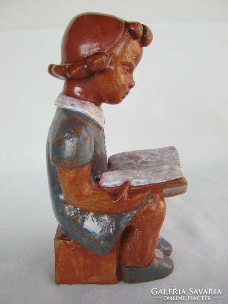 Mária the stonemason is a girl reading ceramics