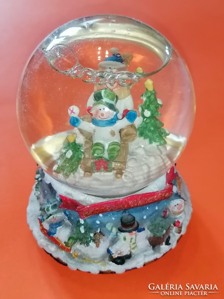 Large, mechanical Christmas snow globe with musical structure.