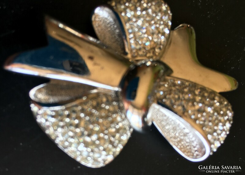 Bow. Silver-plated metal brooch with crystals