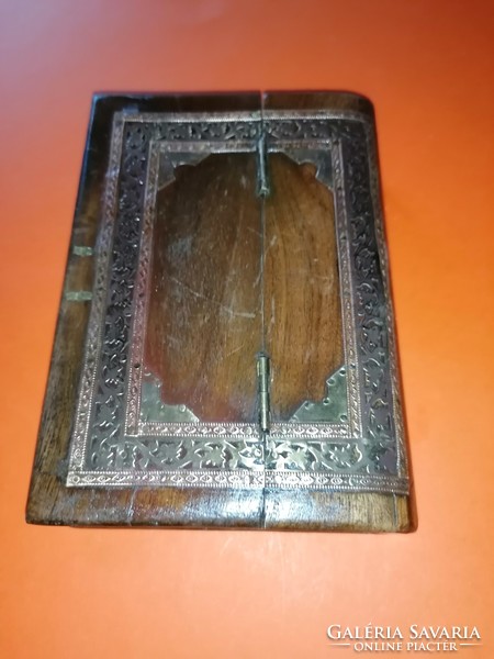 An old, book-shaped, decorative wooden secret box opens interestingly
