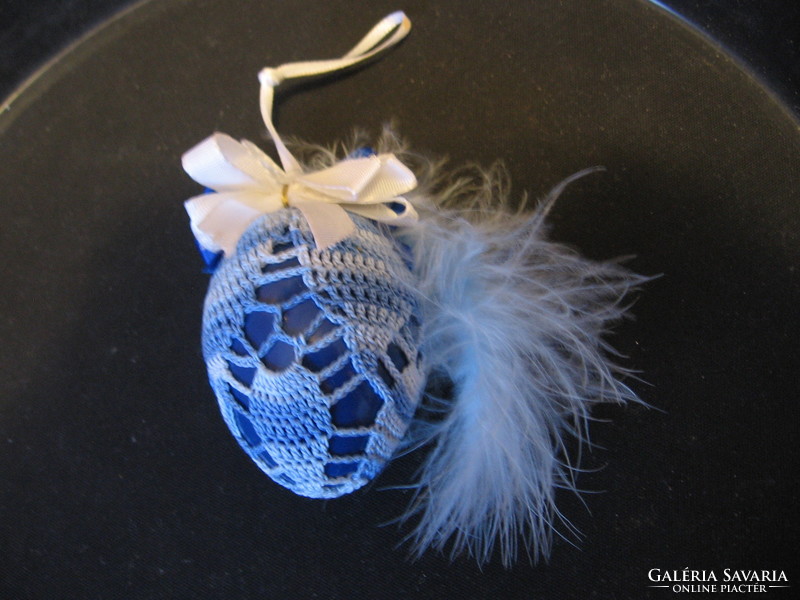 Crafted plastic egg decorated with feathers and crochet